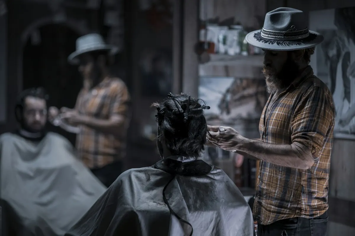 Barber working on a client in a dim shop
